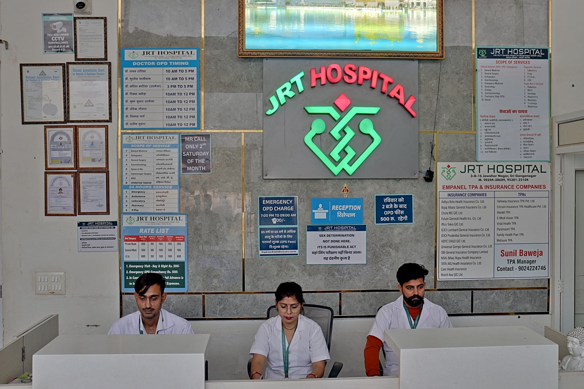 Hospital reception desk with staff assisting patients